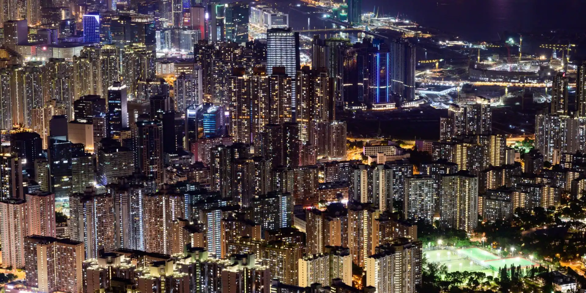 A dense city skyline lit up at night, seen from above